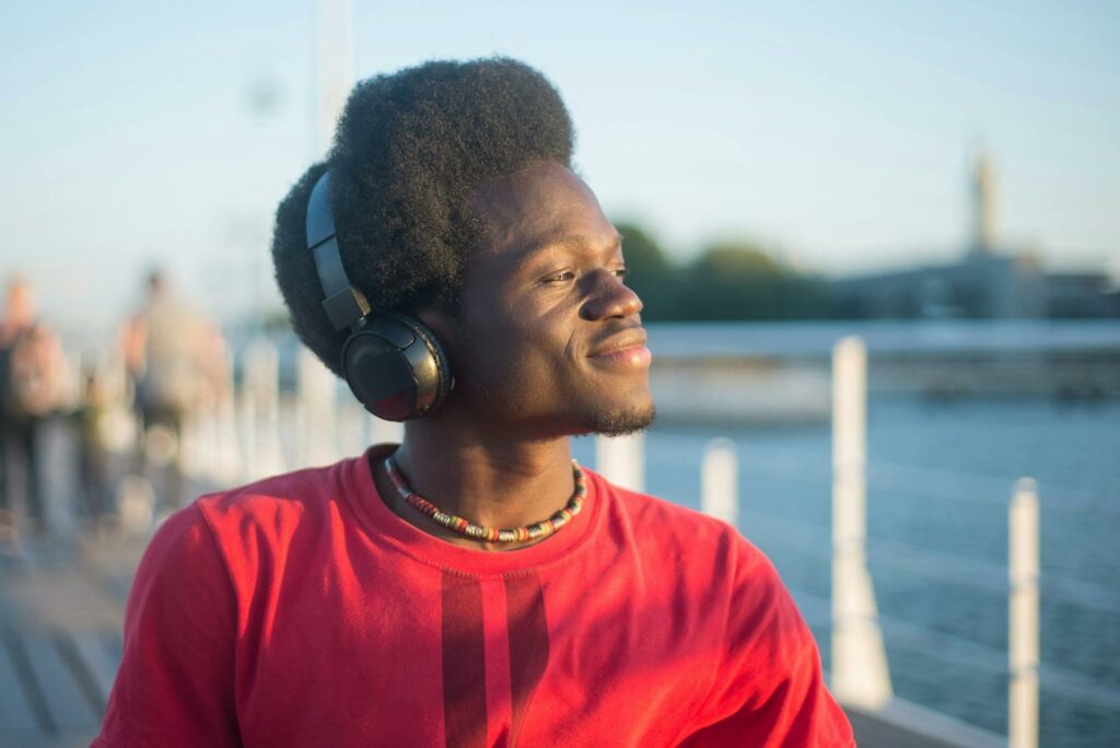 Man in Red Crew Neck Shirt Wearing Black Headphones