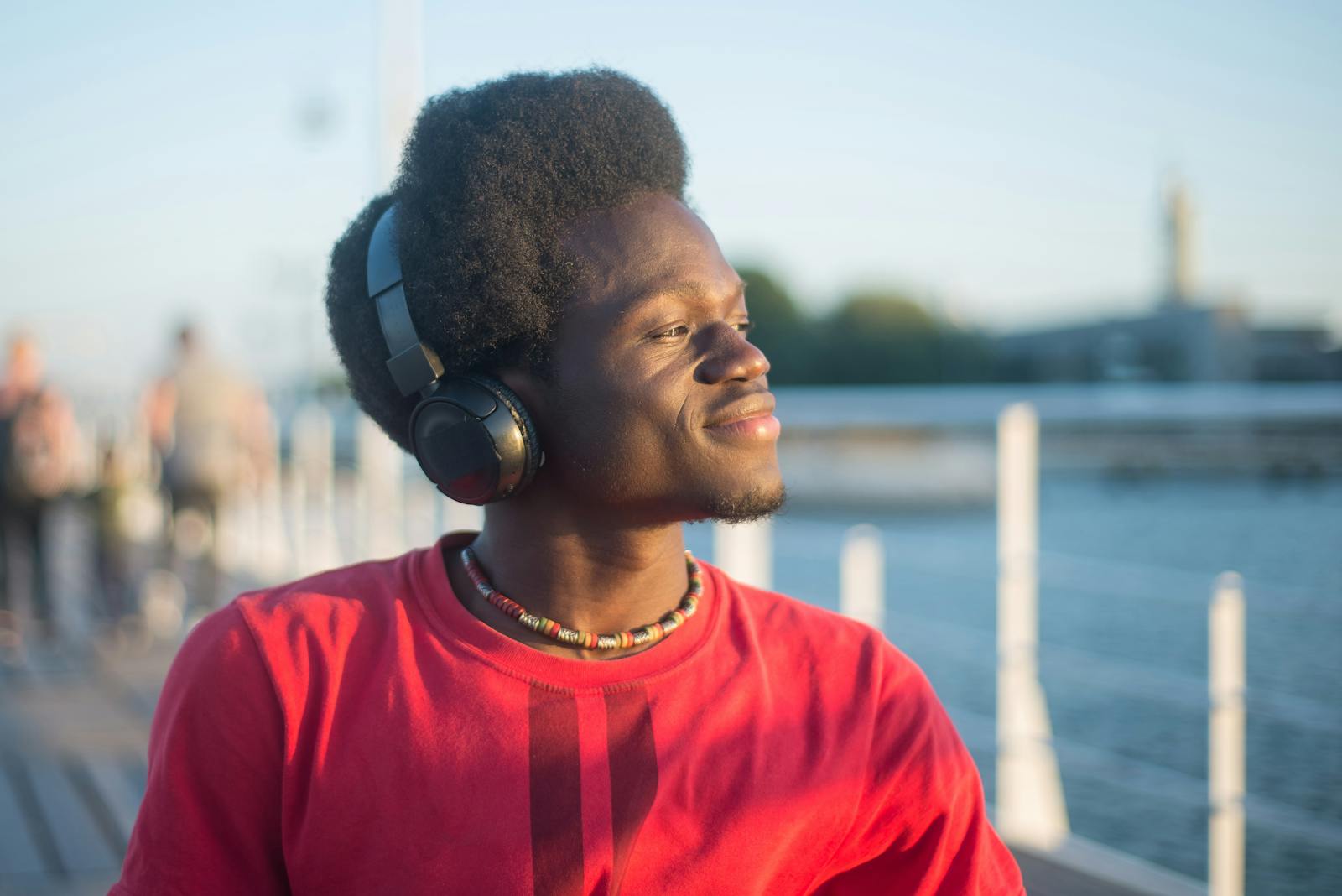 Man in Red Crew Neck Shirt Wearing Black Headphones